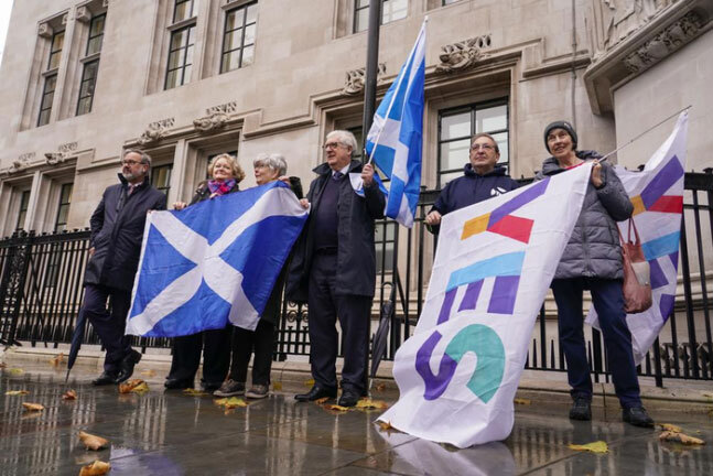 스코틀랜드 분리독립 지지자들이 23일(현지시간) 영국 런던의 대법원 앞에서 스코틀랜드 국기와 분리독립 추진 찬성 문구가 새겨진 깃발을 들고 서 있다. 런던|AP연합뉴스