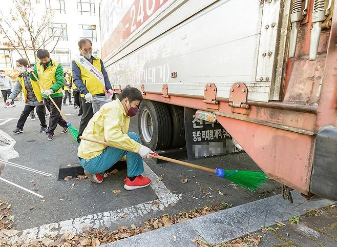 김태우 서울 강서구청장이 23일 오후 지역 주민들과 함께 방화역 일대를 찾아 주차되어 있는 차량 밑에 버려진 담배꽁초를 끄집어 내고 있다.강서구 제공