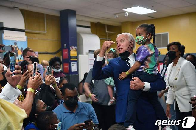 조 바이든 미국 대통령이 지난 6월 21일(현지시간) 워싱턴의 교회에 마련된 코로나19 백신 클리닉에서 5세 미만 영유아들에게 접종을 위해 방문한 가족의 환영을 받고 있다. ⓒ AFP=뉴스1 ⓒ News1 우동명 기자