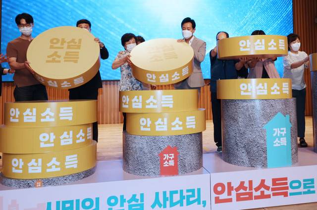 지난 7월 4일 '서울 안심소득 시범사업' 출범식에서 오 시장(가운데 오른쪽)이 가구소득이 낮을수록 안심소득 지급액이 많다는 내용의 퍼포먼스를 하고 있는 모습. 연합뉴스