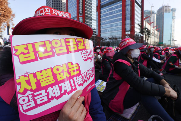 전국학교비정규직노동조합 조합원들이 25일 오후 서울 영등포구 여의대로에서 열린 총파업대회에서 팻말을 들고 있다. [사진 = 연합뉴스]