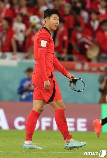 손흥민이 24일 오후(현지시간) 카타르 알라이얀 에듀케이션 시티 스타디움에서 열린 2022 카타르 월드컵 조별리그 H조 1차전 대한민국과 우루과이 경기에서 마스크를 벗고 땀을 닦고 있다. 손흥민의 오른쪽 양말이 우루과이 카세레스의 태클로 찢겨져 있다. /사진=뉴스1