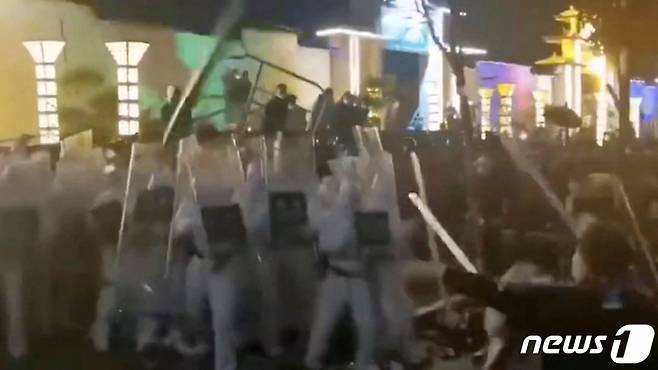 23일(현지시간) 세계 최대 규모 아이폰 생산지인 중국 정저우의 폭스콘 공장에서 근로자들이 임금 체불과 코로나19 방역에 항의하는 시위를 벌이며 보안요원과 충돌을 하고 있다.   /로이터=뉴스1