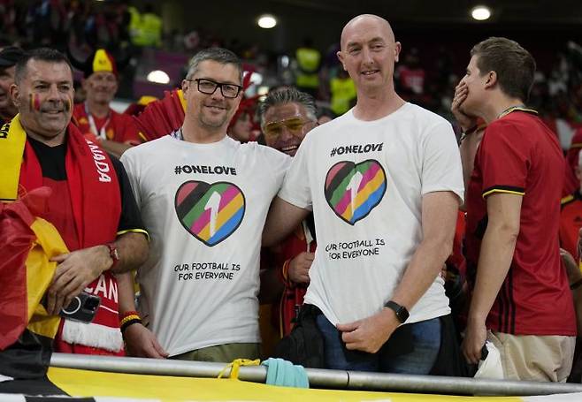 다양성과 포용을 상징하는 '원 러브'(OneLove) 셔츠를 입은 벨기에 축구팬들이 23일(현지시간) 벨기에와 캐나다의 2022 카타르 월드컵 조별리그 F조 1차전 경기가 열리는 도하 아흐마드 빈 알리 스타디움에서 포즈를 취하고 있다. 사진=AP연합뉴스