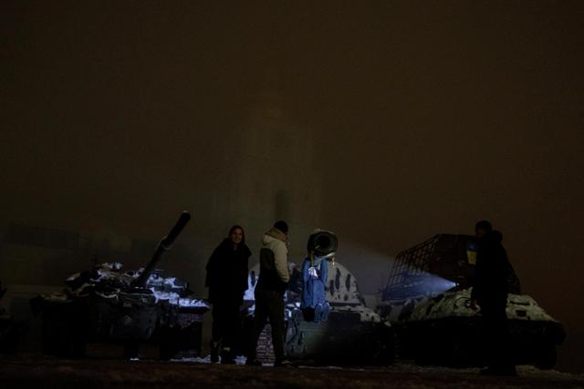 러시아의 미사일 공격 후 대규모 정전이 발생한 24일 우크라이나 키이우에서 마을 어린이가 파괴된 러시아 탱크를 장난감 삼아 놀고 있다. 키이우=AP 연합뉴스