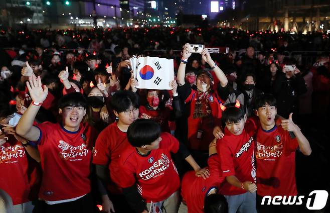 붉은악마와 시민들이 지난 24일 서울 광화문광장에서 2022 카타르 월드컵 H조 조별리그 1차전 대한민국과 우루과이의 경기 거리응원을 마치며 취재진을 향해 포즈를 취하고 있다./사진= 뉴스1