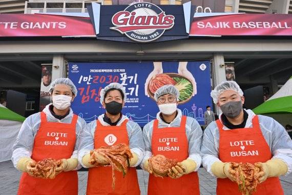 롯데 자이언츠 이석환 대표(왼쪽 두번째)와 김원중, 박세웅, 안치홍이 지난 25일 오전 부산 동래구 사직야구장 광장에서 열린 '부산 롯데그룹 1만2030포기 김장 담그기 행사'에서 김장을 하고 있다. 뉴스1