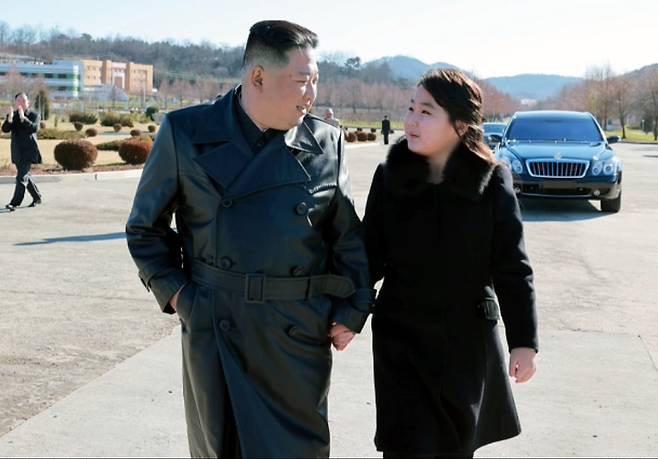 [서울=뉴시스] 북한 조선중앙TV가 27일 북한 김정은 국무위원장이 신형대륙간탄도미사일 화성포-17형 시험발사 참여했던 공로자들과 함께 기념사진을 찍고 그들의 노력을 평가했다고 보도했다. 이날 김 국무위원장은 둘째 딸을 데리고 나와 과시하는 모습을 보였다. 이날 공개된 사진에서 털이 달린 검은색 긴 코트를 입은 둘째 딸은 가죽 롱코트 차림의 김 위원장의 팔짱을 끼며 나란히 걷는가 하면, '화성-17형' 발사 공로자들에게 박수를 보내는 등 자연스러운 모습을 연출했다. (사진=조선중앙TV 캡쳐) 2022.11.27. photo@newsis.com *재판매 및 DB 금지