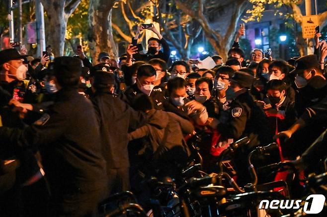 27일(현지시간) 중국 상하이에서 정부의 고강도 제로 코로나19 봉쇄 정책에 항의하고 우루무치 화재 희생자를 추모하는 주민들이 진압 경찰과 충돌을 하고 있다. ⓒ AFP=뉴스1 ⓒ News1 우동명 기자