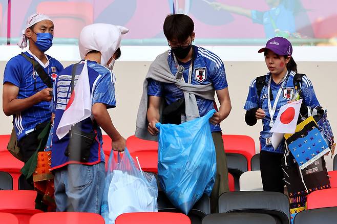 일본 응원단이 27일(현지 시각) 카타르 알라이얀 아흐마드 빈 알리 스타디움에서 2022 카타르 월드컵 조별리그 E조 일본과 코스타리카의 경기가 끝난 후 경기장을 청소하고 있다. 일본은 이날 코스타리카에 0-1로 패했다. /AFP 연합뉴스