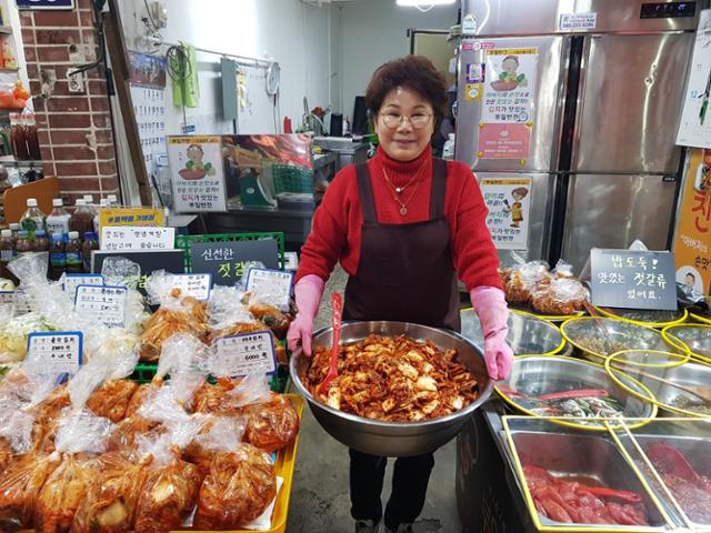 부산 '초량전통시장' 안에서 20년가량 장사를 이어온 부일반찬가게 사장 김두리씨가 직접 담근 김치를 들어 보이고 있다.