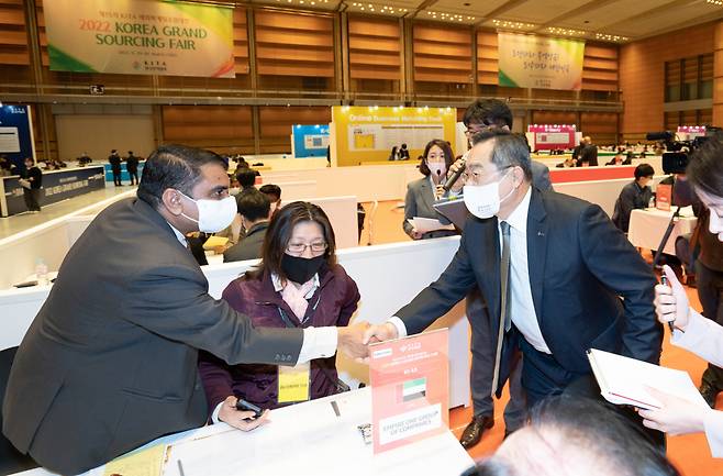 Korea International Trade Association Chairman Koo Ja-yeol (right) greets a foreign buyer visiting the 2022 Korea Grand Fair, which kicked off Tuesday at Coex in Seoul. (KITA)