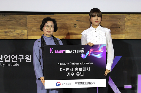 Lee Jae-ran, president of the Korea Cosmetic Industry Institute, left, and singer Yubin, a former member of disbanded girl group Wonder Girls, stand for a photo. Yubin was named the ambassador for the 2022 K-Beauty Brands Show. [KOREA COSMETIC INDUSTRY INSTITUTE]