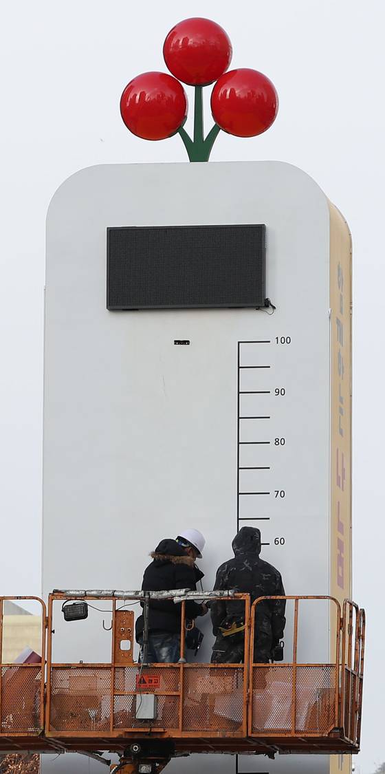 Workers set up the "thermometer of love," which will display the fundraising progress of the Community Chest of Korea's charity campaign, in Gwanghwamun Square in central Seoul, Tuesday. [YONHAP]