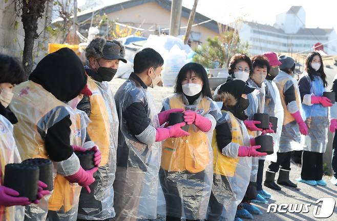 30일 오후 서울 노원구 상계동 일대에서 고려아연 임직원들과 적십자 봉사원들이 취약계층에게 전달할 연탄을 나르고 있다. 2022.11.30/뉴스1 ⓒ News1 송원영 기자