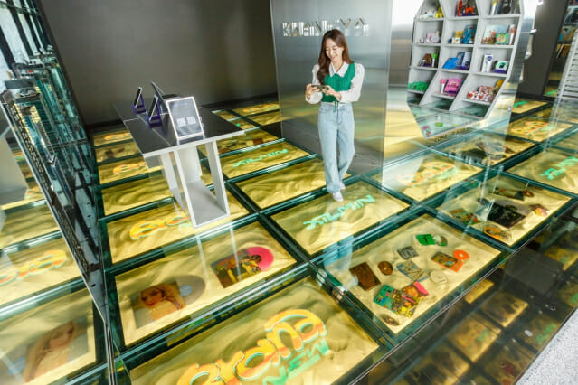 SM브랜드마케팅의 플래그십스토어 '광야@서울'을 방문한 고객이 LG디스플레이 투명 OLED 33대로 구성된 '투명 OLED 플로어 솔루션'을 경험하고 있다.(사진=LG디스플레이)