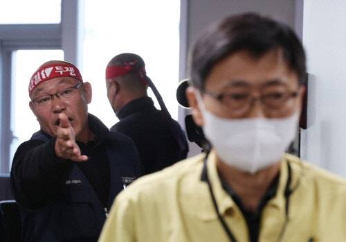 안전운임제 일몰제를 폐지 등을 요구하며 총파업 중인 민주노총 공공운수노조 화물연대본부(이하 화물연대) 관계자들이 30일 오후 정부세종청사 국토교통부에서 열린 2차 교섭이 결렬되자 대표로 참석한 구헌상 국토교통부 물류정책관에게 항의하고 있다. 사진 연합뉴스