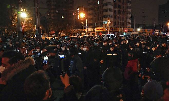 지난 27일 중국 베이징에서 코로나19 봉쇄 정책에 항의하는 시위대가 경찰과 대치하고 있다. 시민들은 정부에 항의하는 의미를 담은 ‘백지’를 들고 28일 새벽까지 시위를 이어갔다. 베이징=AP뉴시스