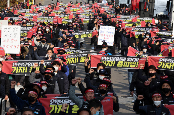 화물연대 서울경기지부 총파업 출정식 - 24일 오전 경기도 의왕시 내륙컨테이너기지(ICD) 앞에서 열린 화물연대 서울경기지부 총파업 출정식에서 노조원들이 구호를 외치고 있다.     민주노총 공공운수노조 화물연대본부는 안전운임제 일몰제 폐지와 적용 차종?품목 확대 등을 요구하며 이날 0시부터 총파업에 돌입했다. 2022.11.24 연합뉴스