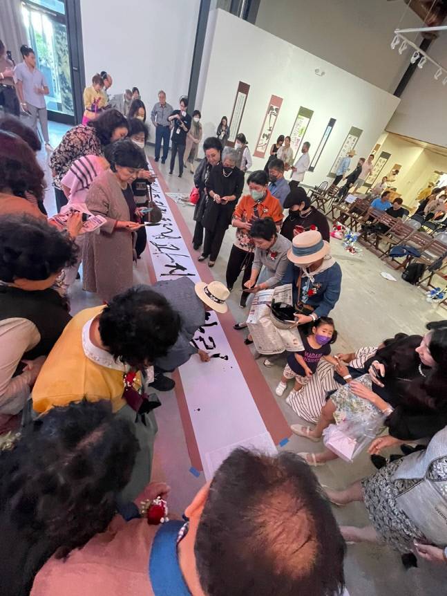 한국서예협회 전시회에서 한 관람객이 붓을 잡고 한글을 쓰고 있다. 제공 | 삼평장학재단