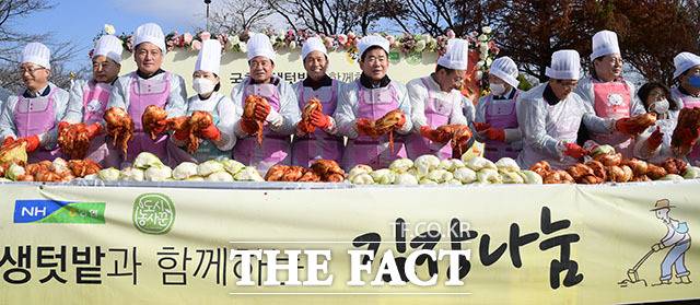 이날 여야 국회의원과 내빈들이 김장 작업을 앞두고 기념사진을 남기고 있다.
