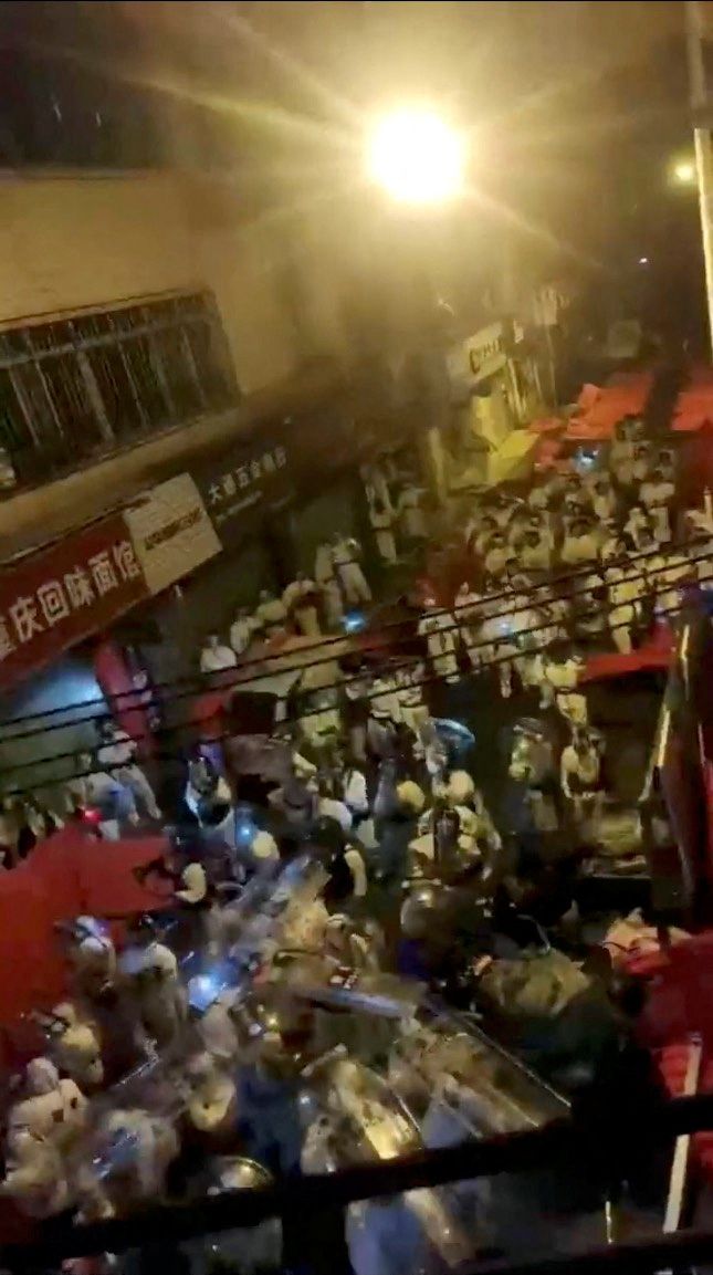 2022년 11월 30일 중국 남부 광둥성 광저우시에서 코로나 방역 조치에 항의하는 시위대와 방호복을 입은 폭동 진압 경찰이 뒤섞여 있다. /로이터 연합
