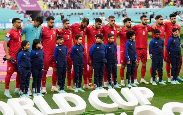 이란 월드컵 국가대표팀 선수들이 지난달 21일 카타르 도하 칼리파 국제경기장에서 열린 2022 카타르 월드컵 B조 잉글랜드와의 경기에서 국가가 나오는 동안 침묵하고 있다. 도하=AP 연합뉴스