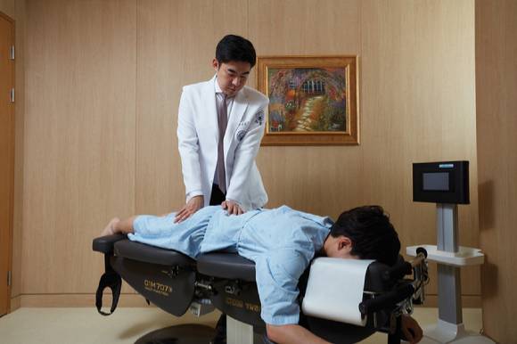 이진호 자생한방병원 병원장이 허리디스크 환자에게 추나요법을 하고 있다. [사진=자생한방병원]