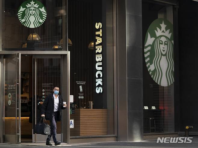 [뉴욕=AP/뉴시스] 지난 1월 미국 뉴욕의 스타벅스 커피숍에서 한 남성이 커피를 들고 나오고 있다. 뉴욕은 인텔리전스유닛(EIU)이 1일(현지시간) 발표한 전 세계 생활비 지수에서 싱가포르와 함께 생활비가 가장 비싼 도시 공동 1위에 올랐다. 2022.12.01.