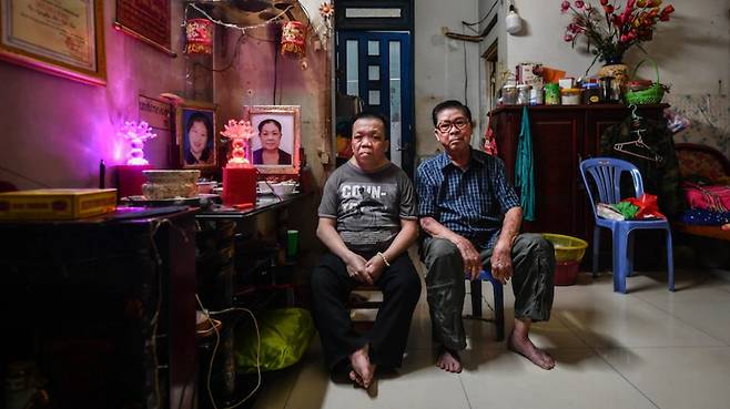 빈 판 씨(오른쪽)와 그의 아들이 집에 마련된 제단에서 포즈를 취하고 있다. 그는 코로나로 아내와 딸을 잃었다. / Hiệu Nguyễn