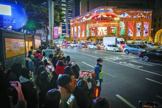 지난해 11월 서울 신세계 명동 본점 외관에 설치 돼 있는 미디어 파사트를 보기위해 모인 시민들로 인도가 북적이고 있다. 전민규 기자