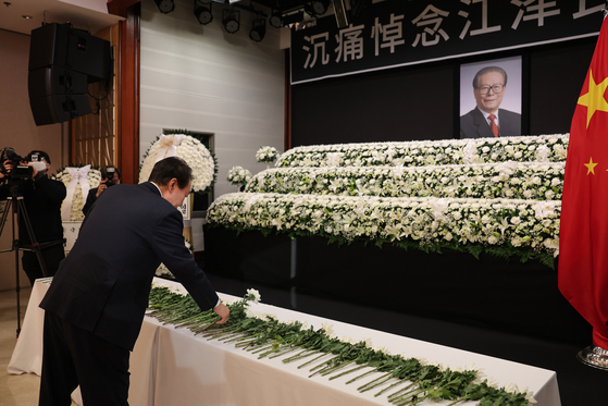 President Yoon Suk-yeol pays respects at a memorial altar for former Chinese leader Jiang Zemin at the Chinese Embassy in central Seoul on Friday. Yoon also sent a letter to Chinese President Xi Jinping to express his condolences on behalf of the Korean government and the people and recognized Jiang’s role in establishing bilateral ties in 1992. [YONHAP]
