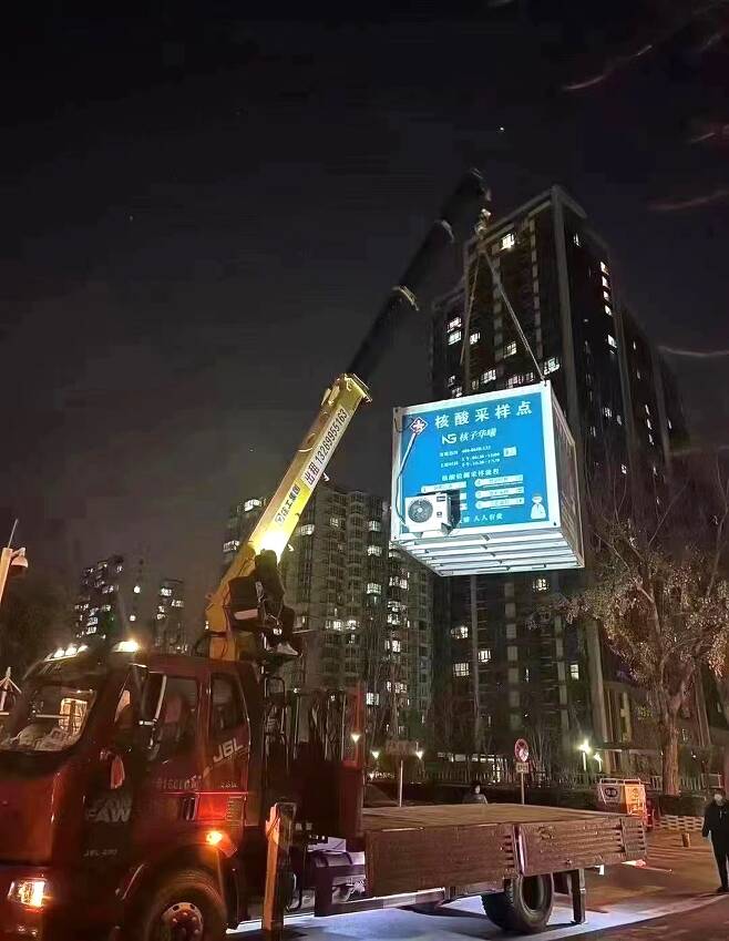 중국 수도 베이징에서 코로나19 방역 긴급 완화 조치를 내놓은 지난 2일 밤 시내의 한 코로나19 핵산 상시 검사소가 철거되고 있다. 소셜미디어 캡처