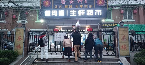 11월 28일 오전 중국 베이징 차오양구의 한 아파트에서 주민들이 철문 사이로 생필품을 구입하고 있다. 이 아파트가 봉쇄되면서 내부에서 영업하던 상점으로 출입도 차단됐다. 사진=정지우 특파원