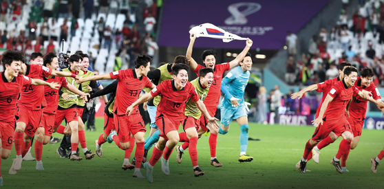 한국이 지난 3일 열린 카타르 월드컵 조별리그 H조 3차전에서 포르투갈을 꺾고 16강 진출에 성공한 뒤 선수들이 태극기와 함께 그라운드를 달리며 기쁨을 만끽하고 있다. 연합뉴스