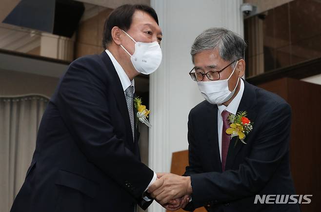 [서울=뉴시스] 국회사진기자단 = 윤석열 국민의힘 대선 후보가 9일 서울 중구 프레스센터에서 열린 신평 변호사 출판기념회에서 신 변호사와 악수하고 있다. 2021.11.09. photo@newsis.com