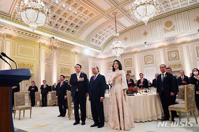 [서울=뉴시스] 전신 기자 = 윤석열 대통령과 부인 김건희 여사가 5일 청와대 영빈관에서 열린 응우옌 쑤언 푹 베트남 국가주석 방한 국빈만찬에서 국기에 대한 경례를 하고 있다. (대통령실통신사진기자단). 2022.12.05. photo1006@newsis.com