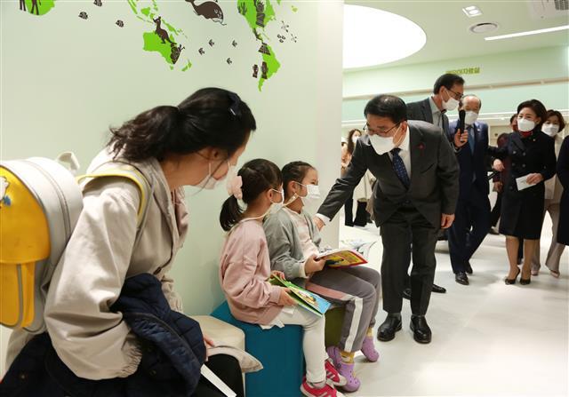문헌일(왼쪽 네 번째) 서울 구로구청장이 항동 서울푸른수목원 내에 문을 연 항동푸른도서관에서 책을 보는 어린이에게 인사를 건네고 있다.구로구 제공