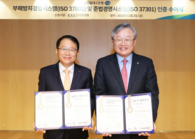 강명수 한국표준협회 회장(왼쪽)과 암성훈 DGB대구은행장이 부패방지경영시스템과 준법경영시스템 인증서를 들어보이고 있다.
