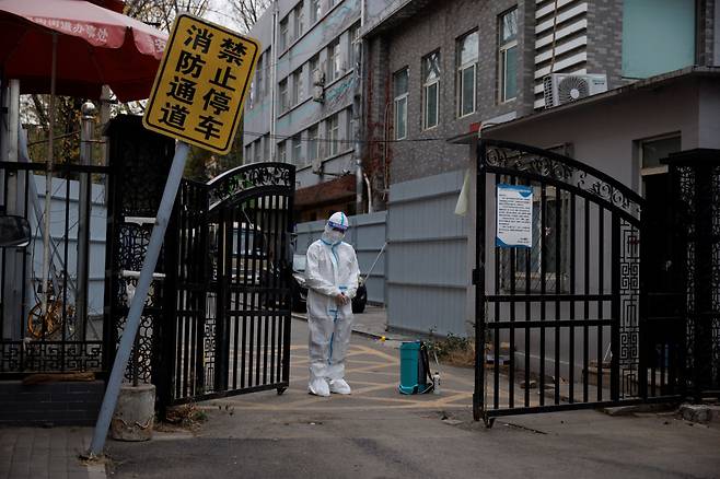 한 방역요원이 중국 베이징의 봉쇄된 주택지구 입구를 지키고 있다. /연합뉴스