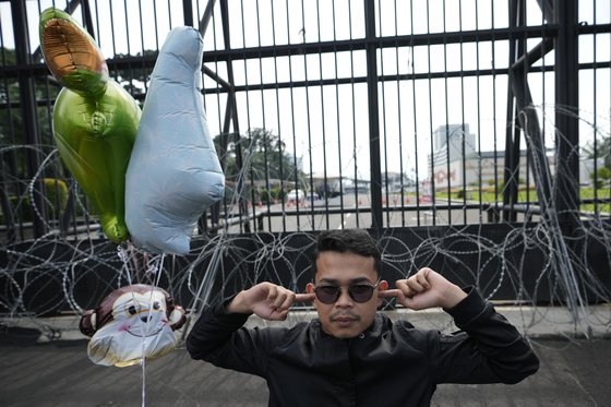 인도네시아의 한 남성 활동가가 수도 자카르타의 국회 앞에서 자신의 귀를 막는 동작을 하며 혼전 성관계 금지 등을 담은 형법 개정안에 대한 반대 시위를 하고 있다. AP=연합뉴스