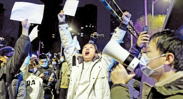 중국에서 ‘제로 코로나’ 정책을 규탄하는 시위가 확산하고 있다. 시위대를 처벌할 법적 근거를 찾지 못하도록 아무런 구호를 적지 않은 A4 용지를 들고 시위에 나서고 있다. 28일 베이징에서 A4 용지를 든 시민들이 구호를 외치고 있다. /로이터연합뉴스