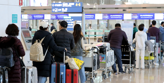 Travelers off to international destinations stand in line to check in their baggage at Incheon International Airport on Dec. 5. [NEWS1]