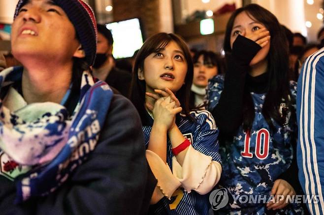 일본의 승리 염원하는 팬들 (도쿄 AFP=연합뉴스) 2022 국제축구연행(FIFA) 카타르 월드컵 일본과 크로아티아의 16강전이 열린 6일 도쿄의 술집에서 팬들이 경기를 보며 안타까워하고 있다. 2022.12.6