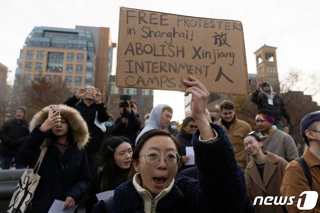4일(현지시간) 미국 뉴욕에서 시민들이 모여 중국의 제로 코로나 정책에 반대하는 시위를 열고 있다. 한 시위자가 손에 든 팻말에는 "상하이의 시위자들을 석방하라! 신장 수용소를 폐지하라!＂고 적혀 있다. ⓒ 로이터=뉴스1