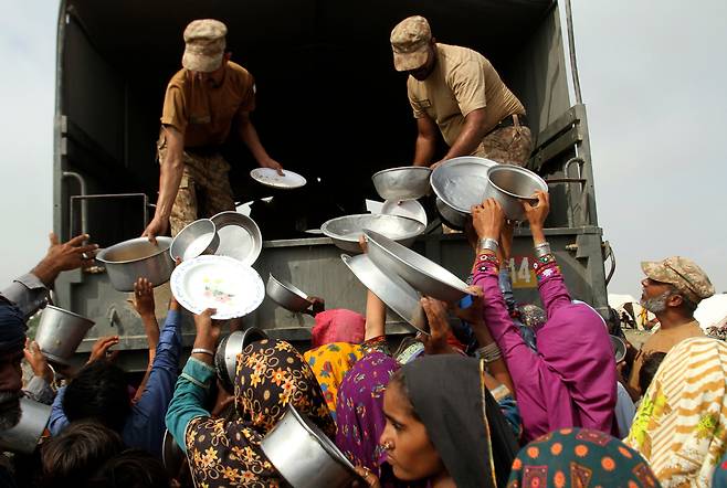 파키스탄 군인들이 펀자브주 라잔푸르의 홍수 피해 지역에서 이재민들에게 음식을 나눠주고 있다. /AP=연합뉴스
