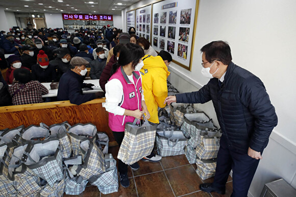 천사무료급식소에서 봉사자들이 도시락 꾸러미를 들고 있다. [사진=광주 북구]