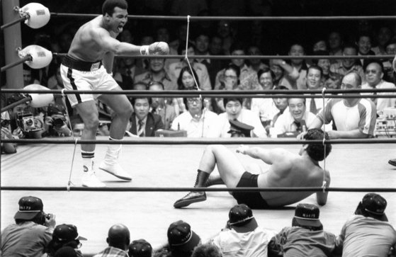 일본 프로 레슬러 안토니오 이노키(오른쪽)가 1976년 6월 16일 도쿄 일본무도관에서 프로 복싱 세계 헤비급 챔피언인 무하마드 알리(왼쪽)와 이종 대결을 벌이고 있다. 교도=연합뉴스