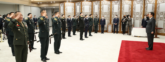 President Yoon Suk-yeol, right, receives salutes after promoting 18 new lieutenant generals including Lt. Gen. Kim Gye-hwan, the new Marine Corps commandant, at the presidential office in Yongsan District in central Seoul Wednesday. [JOINT PRESS CORPS]
