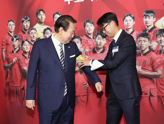 만찬에서 윤석열 대통령에게 주장 완장을 채워주는 한국 축구 국가대표팀 주장 손흥민, 연합뉴스